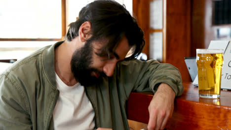 man using mobile phone while having beer 4k