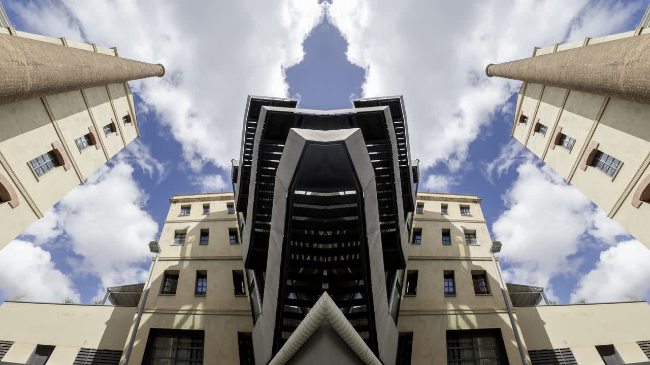 Old factory chimney and apartment buildings in barcelona made into abstract mirrored pattern