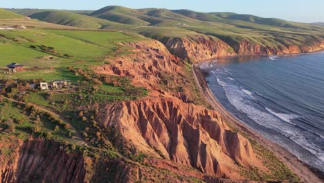 counterclockwise orbit aerial shot of sellicks beach cliffs and house at golden hour, adelaide, south australia