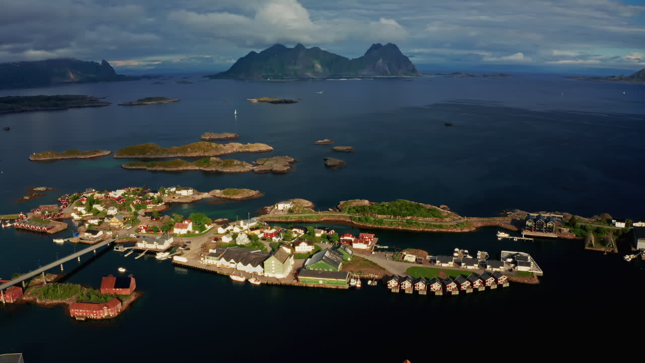 Aerial drone shot over Svolvaer, Lofoten Islands, Norway.
High view of the fishermen cabins and the scenic nordic landscape at sunset.