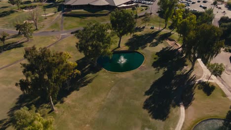 Umlaufende-Luftdrohnenaufnahme-Eines-Brunnens-Auf-Einem-Golfplatz