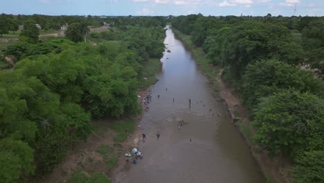 Gente-Lavando-Ropa-Dentro-De-Un-Río-Sucio-En-Haití---Escasez-De-Agua-En-La-Tierra