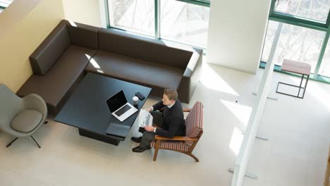 businessman stressed out while going through paperwork and angrily throw papers and documents in the air at modern office lounge - high angle wide view
