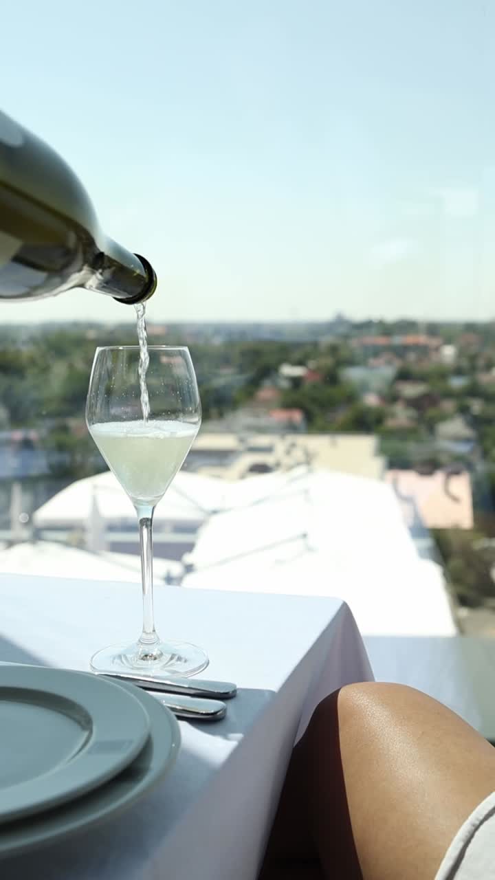 Pouring wine at a restaurant with a city view
