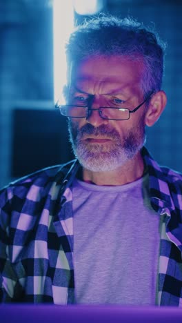 man working on a laptop in a lit room