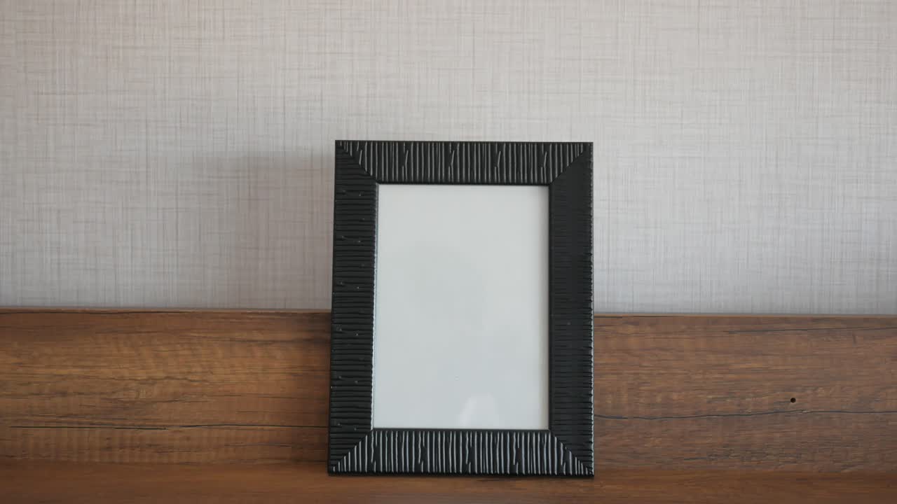 나무 선반 에 있는 검은색 그림 프레임