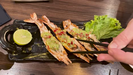 palillos para comer recogiendo camarones de un plato