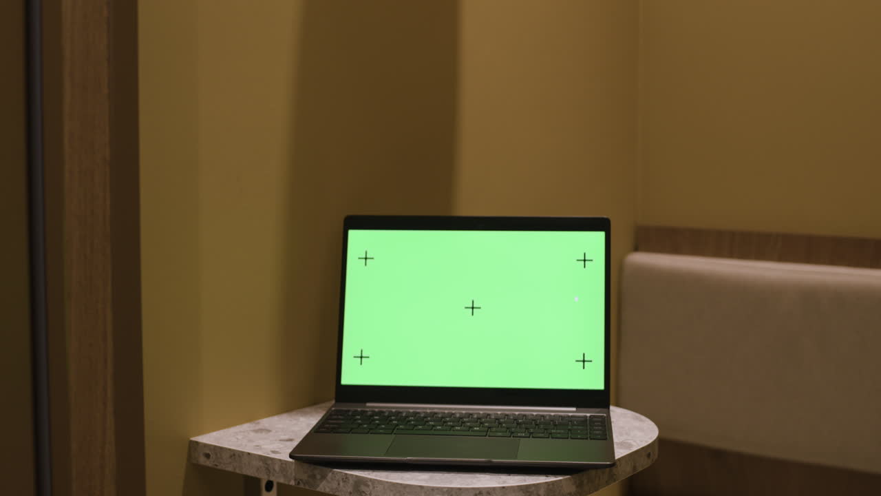 Laptop with green screen in a room