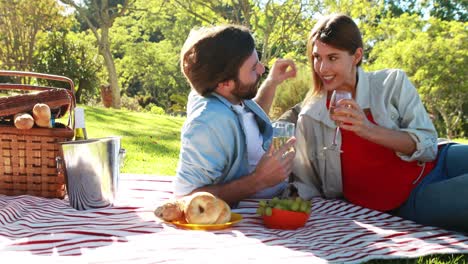 pareja romántica interactuando entre sí mientras beben vino