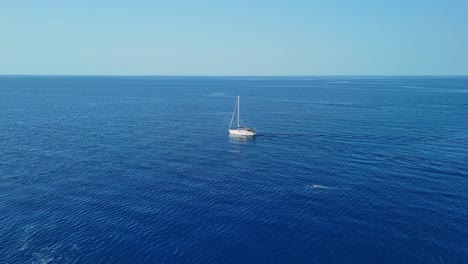 un velero flota pacíficamente en el océano azul sin fin bajo un cielo despejado y soleado