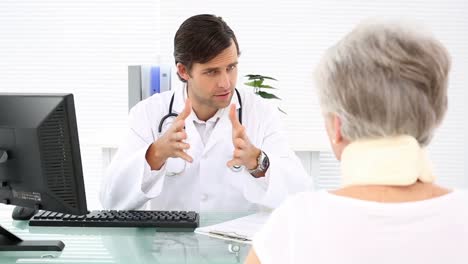 el médico hablando con el paciente jubilado en la abrazadera para el cuello