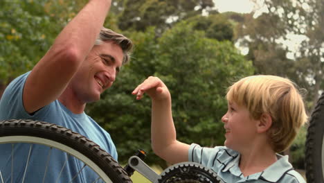 father and his son fixing a bike