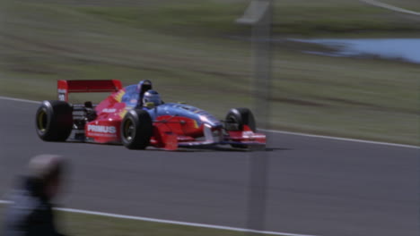 a car races around the track as people stand on the side