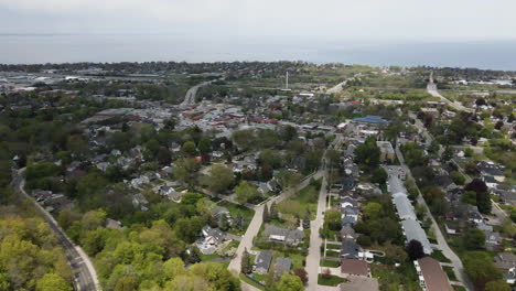 aerial backwards flight showing rural suburb area of hamilton district with lake ontario in backdrop