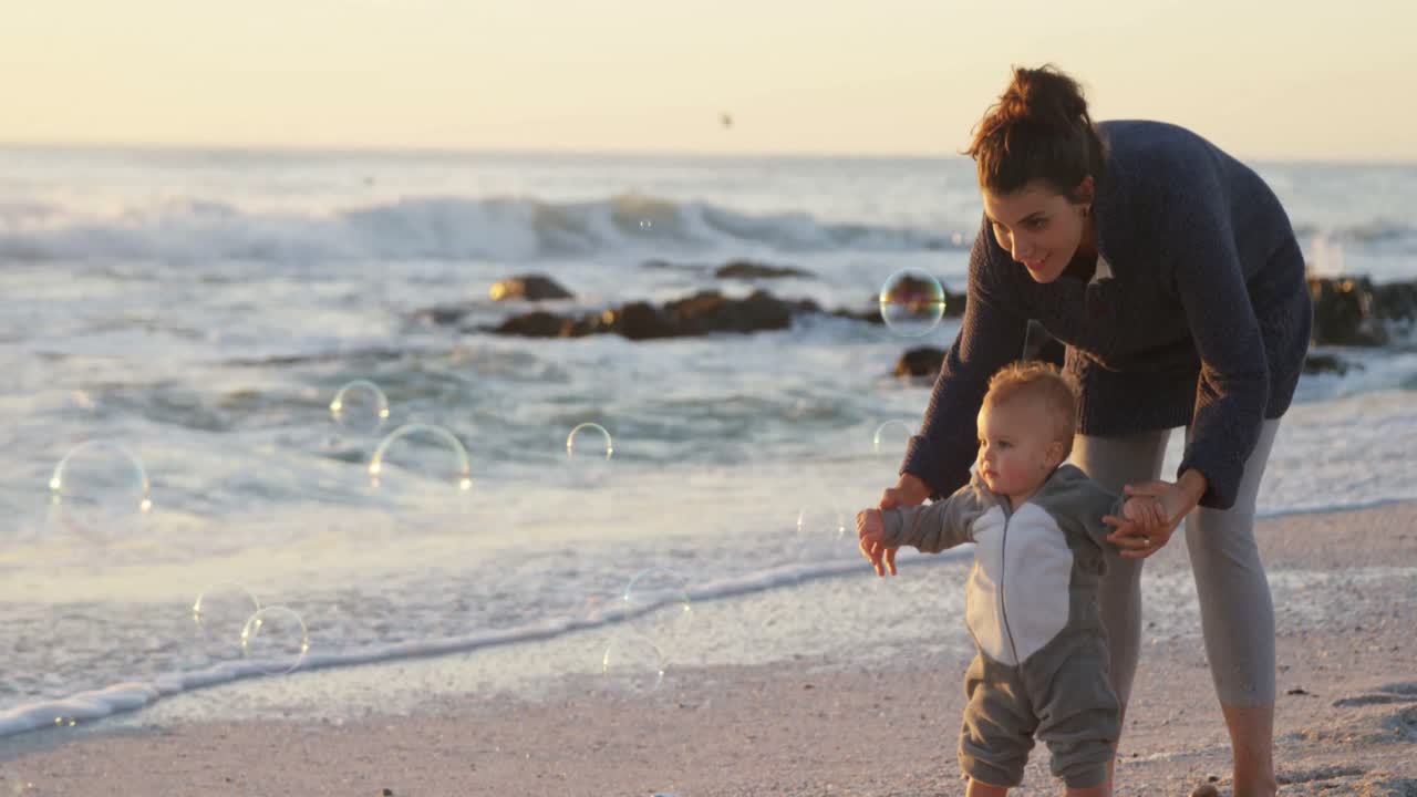 madre y bebé jugando en la playa 4k