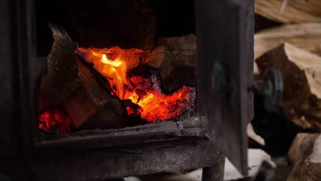 el árbol se quema hermosamente en la chimenea. la mano masculina pone leña en la estufa. quemando fuego en la chiminea. 4k. abrazadera de bucle de chimenea de llama media