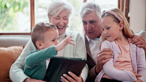 niños, abuelos y tableta en el sofá