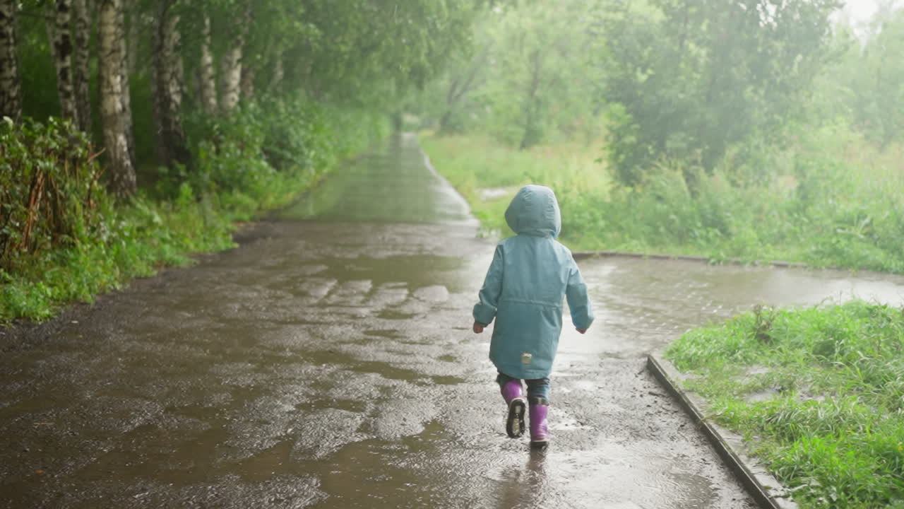Beaming kid dashes across puddle in park cheerful little child engages in delightful game with