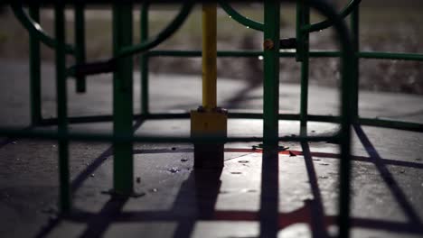 wet carousel spinning at empty children's playground in city park on an autumn night.