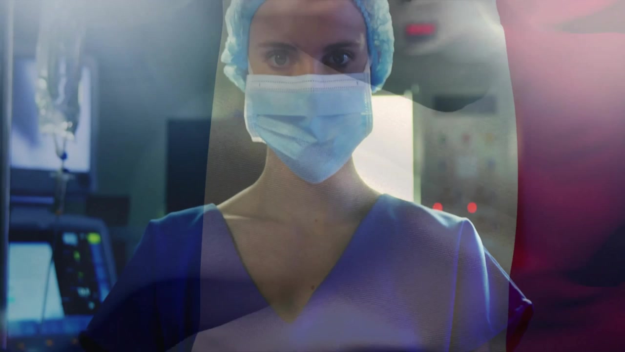 Guanti in sovrapposizione che rivelano un clinico che indossa mascherina e cuffia chirurgica, abbassando le braccia in sala procedure.