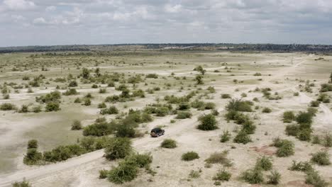 aerial safari jeep driving through african savanna plain