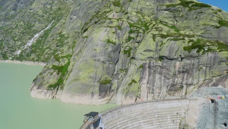 Reservoir with a dam wall under construction, in the Swiss Alps
