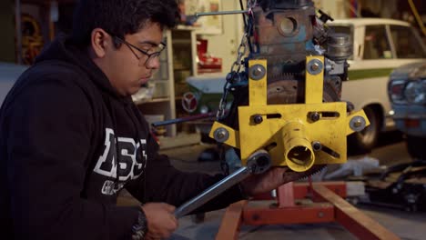 Joven-Mecánico-Apretando-Pernos-En-Un-Soporte-De-Motor-Con-Una-Llave