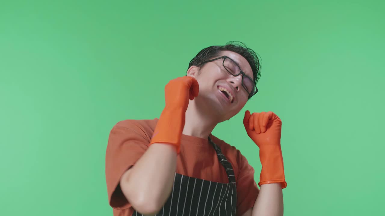 녹색 스크린 스튜디오에 서서 춤을 추는 즐거운 아시아 남성 집주인