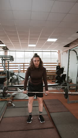 woman performing deadlifts in a gym