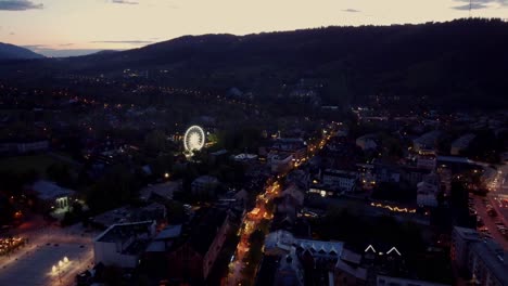 Night-time-flyover-of-Zakopane,-Poland,-a-resort-town-against-the-Tatra-Mountains,-and-its-stunning-Goral-traditional-architecture-4