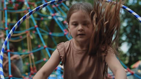 caucasian girl playing with plastic hop at the playground.