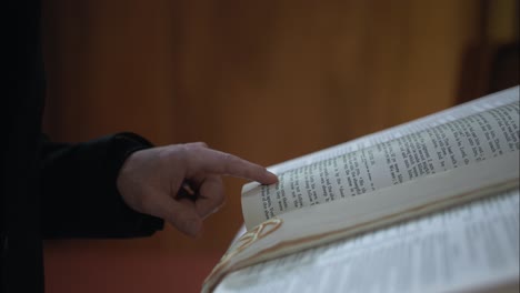 Hand-Eines-Christlichen-Mannes-In-Der-Kirche,-Der-Eine-Bibel-Mit-Nahaufnahme-Der-Seiten-Liest-Und-Studiert