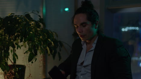 businessman talking on phone in office at night