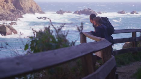 Ein-Paar-Schaut-Von-Einem-Weg-Entlang-Einer-Klippe-Auf-Das-Meer-Hinunter