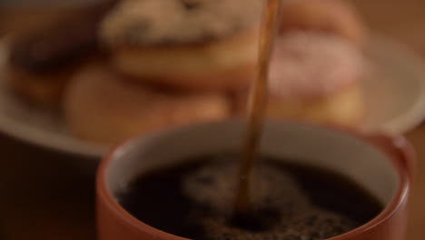 Sirviendo-Café-En-Una-Taza-Con-Donas-Por-La-Mañana-En-Casa-Rodante