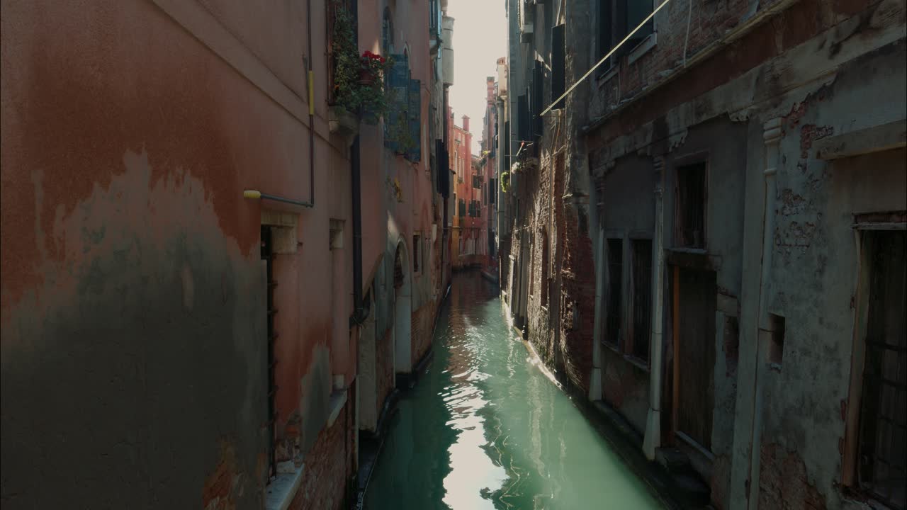 Narrow Venetian Canal with Historic Buildings and Water Reflections