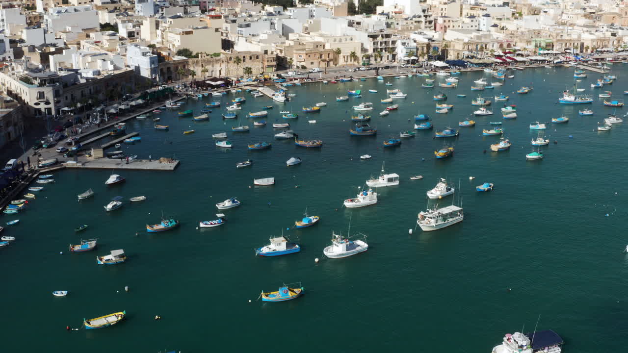 vista aérea del puerto del pueblo de marsaxlokk con botes coloridos en malta - disparo de drones
