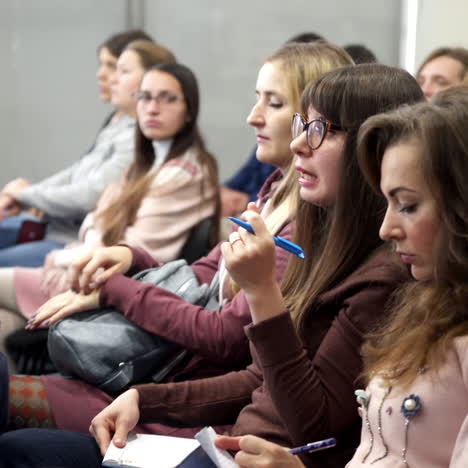 listeners at modern forum. young women are sitting in the audience and listening to the speech at the conference meeting.