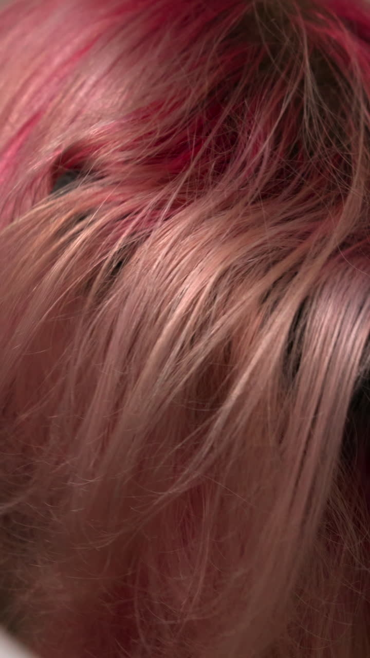 Parrucchiere che asciuga capelli rosa e biondi vivaci