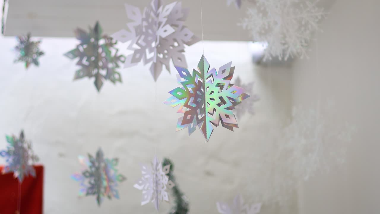 屋内で優しく舞うカラフルな雪の結晶