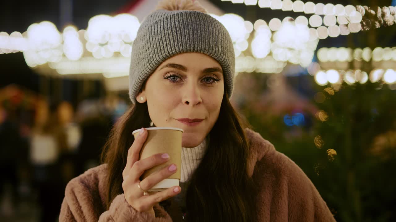 Video ritratto di donna che beve cioccolata calda al mercatino di Natale