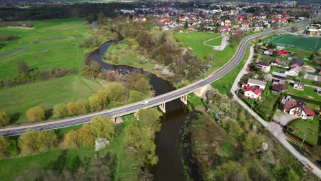 weitwinkel-drone-aufnahme, drehend nach links, łęczna, polen, fluss, alte brücke, autos, stadtansicht