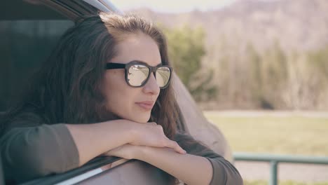 dark haired woman in black sunglasses enjoys beautiful view