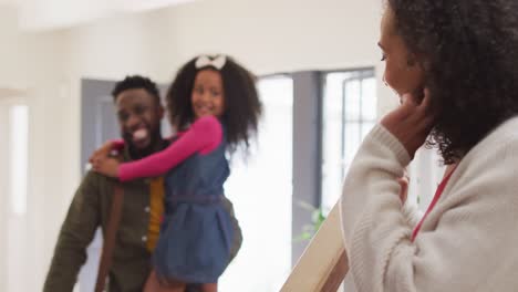 Happy-african-american-father-coming-back-home,-hugging-with-children-and-smiling-to-wife