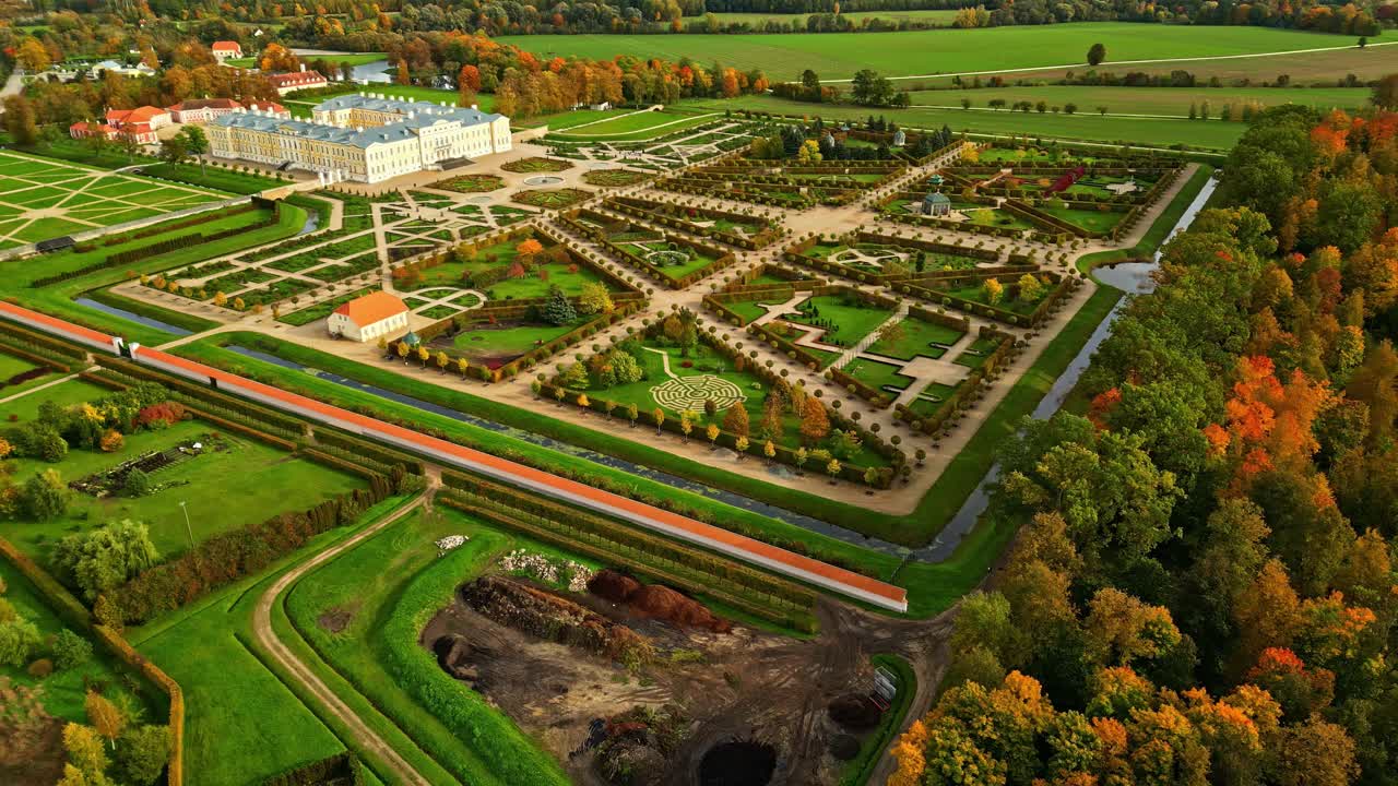 Luchtfoto van een groots barok paleis met symmetrische formele tuinen en geometrische parterres in Europa.