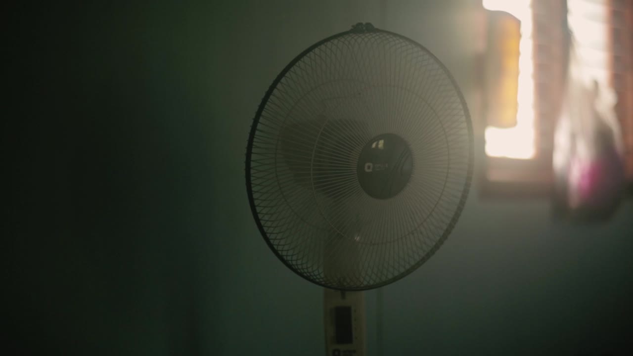 Vintage pedestal fan working on hot day. Static, shallow focus