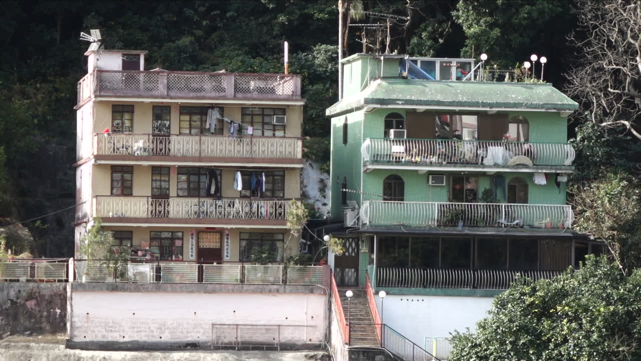 Exterior day shot of two run down apartments in Asia