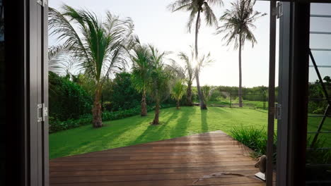 lush tropical coconut tree view out of resort style topical pod home bedroom