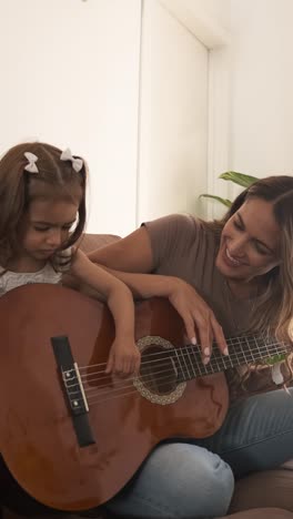 happy mother and daughter drawing in book together at home
