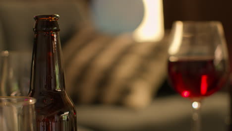 Close-Up-Of-Wine-Glasses-And-Beer-Bottles-On-Table-After-House-Party